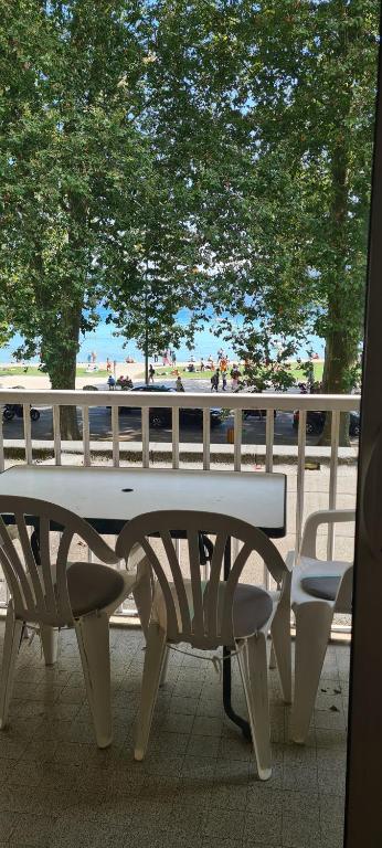 - une table de pique-nique blanche et des chaises en face d'une plage dans l'établissement Flocon, à Annecy