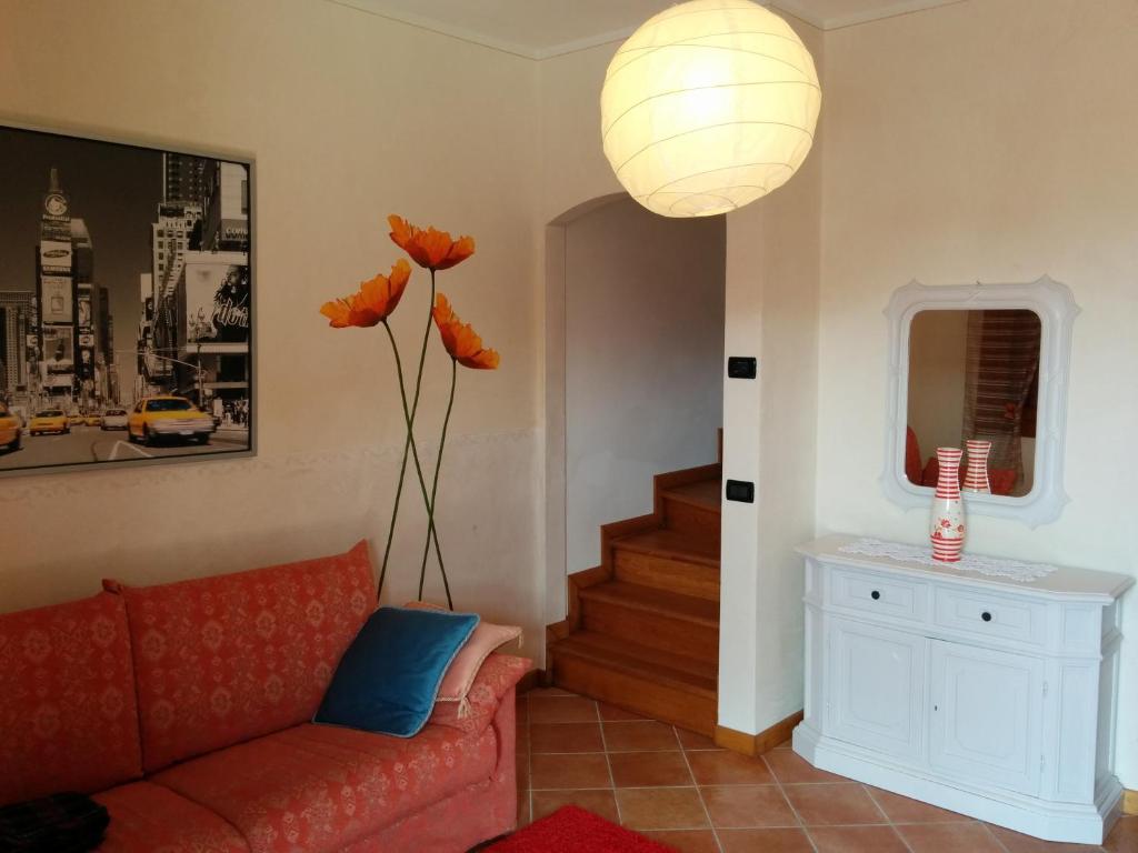 a living room with a red couch and orange flowers at Holiday Home La Moranda in San Fior di Sopra