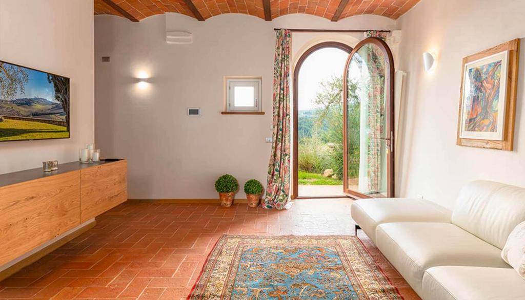 a living room with a couch and a large window at Suite Leonardo in San Gimignano