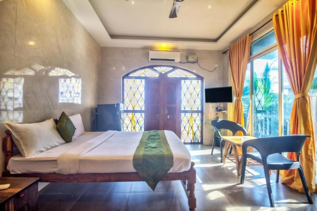 a bedroom with a bed and a table and chairs at Calangute Sea Steps in Calangute