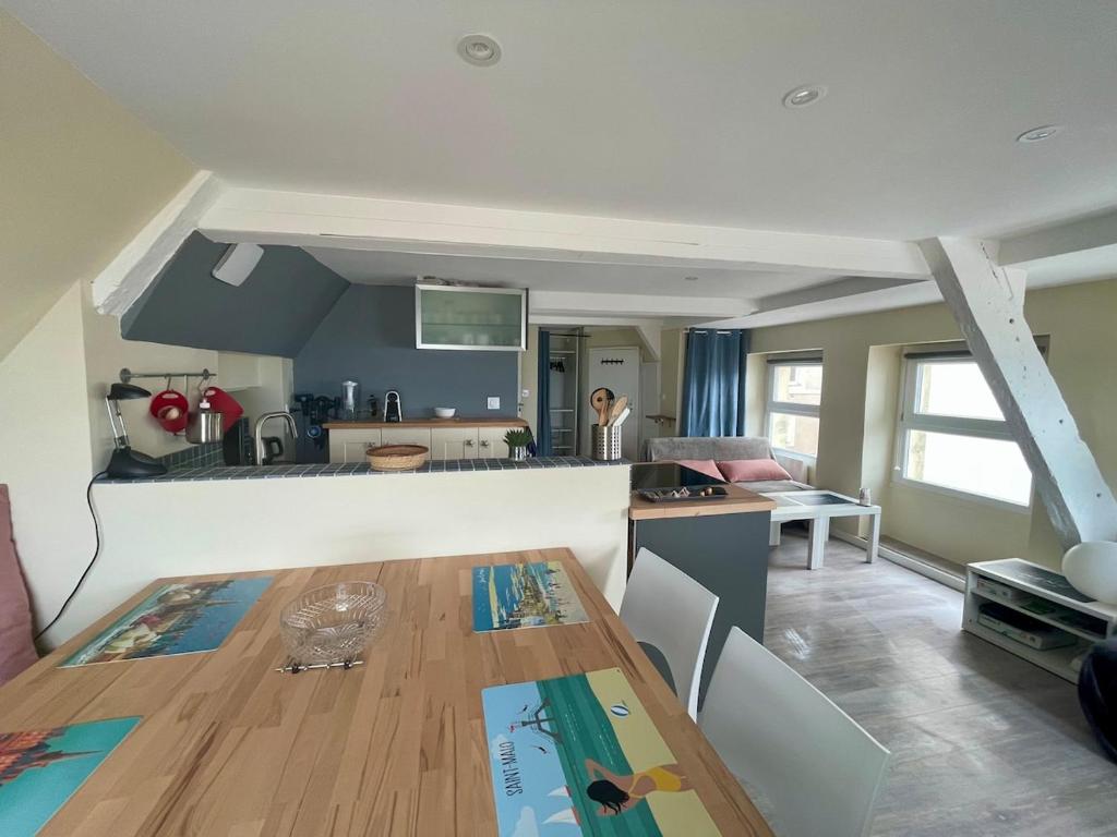 a kitchen and living room with a wooden table at T2 dans l'intra-Muros VUE MER exceptionnelle in Saint Malo