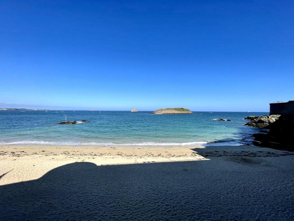 a shadow of a person standing on a beach at T2 dans l'intra-Muros VUE MER exceptionnelle in Saint Malo