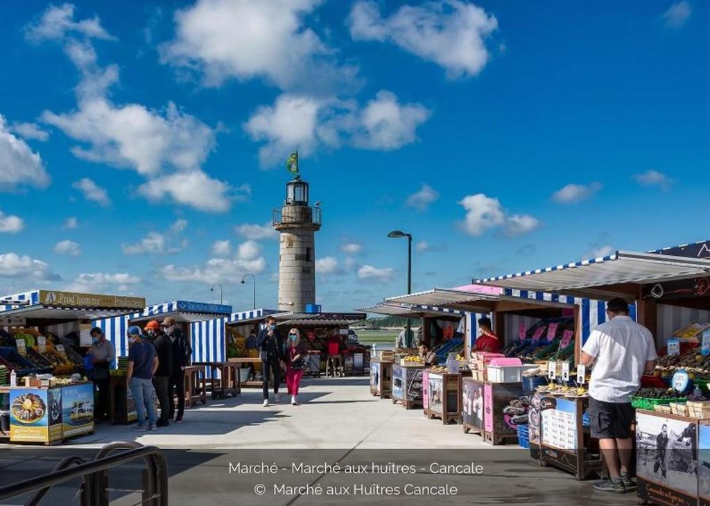 a market with a lighthouse in the background at T2 dans l'intra-Muros VUE MER exceptionnelle in Saint Malo
