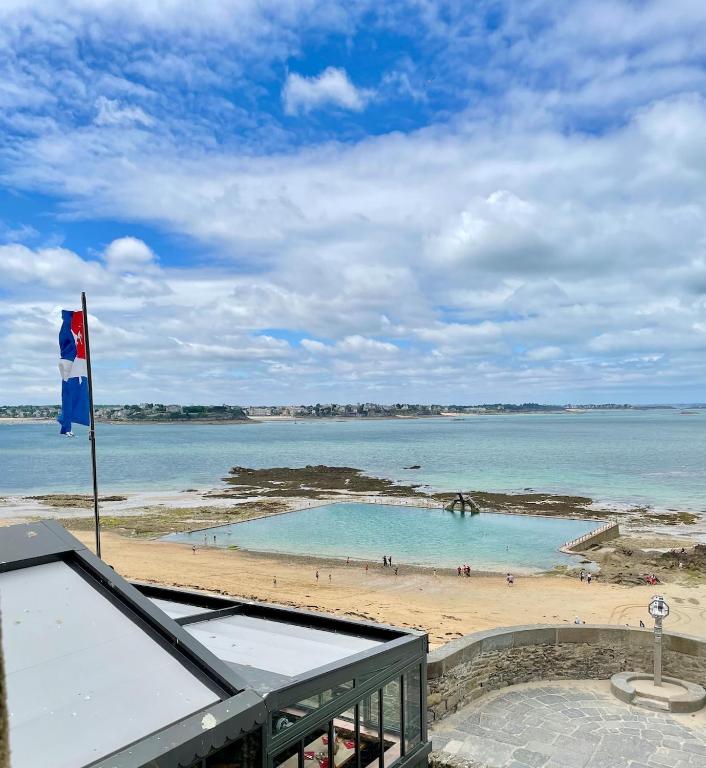 a view of a beach with a flag on a building at T2 dans l'intra-Muros VUE MER exceptionnelle in Saint Malo