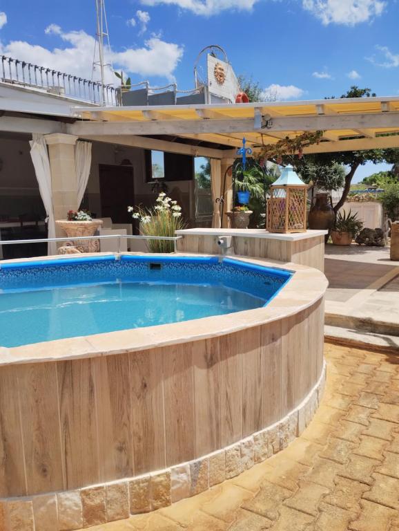 a pool in a backyard with a wooden retaining wall at Villa Allori, via degli allori in San Pietro in Bevagna in San Pietro in Bevagna