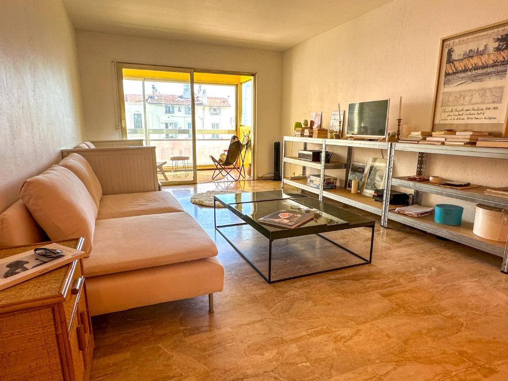 un salon avec un canapé et une table en verre dans l'établissement Emplacement idéal à 500m du Palais, 2P fonctionnel, à Cannes