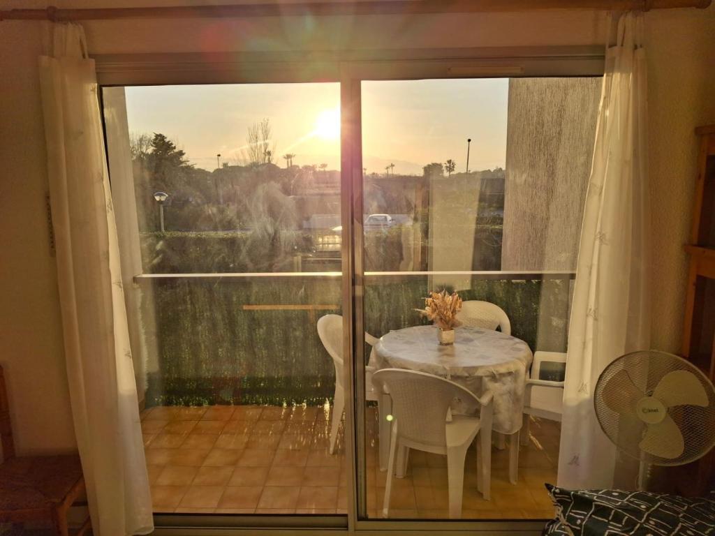 une pièce avec une table et des chaises sur un balcon dans l'établissement Résidence, à Saint Cyprien Plage