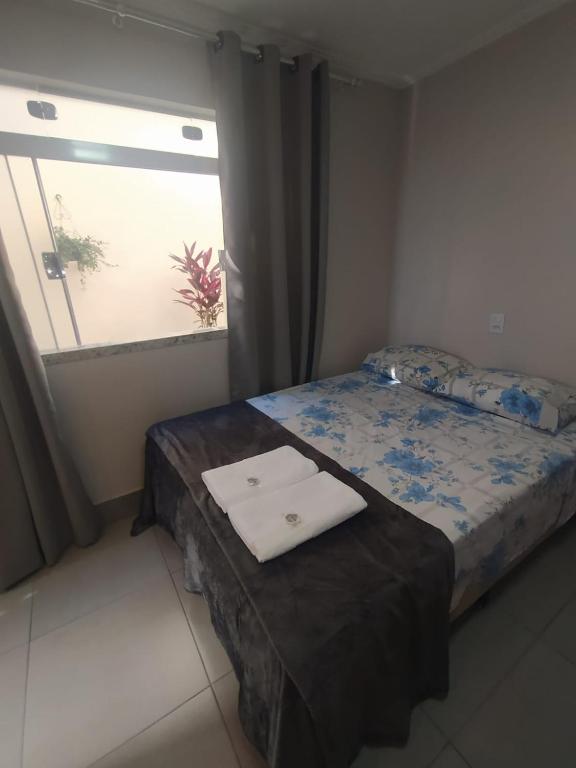 a small bedroom with a bed with a window at Flat Familiar em Capitolio Charlene Paiva in Capitólio
