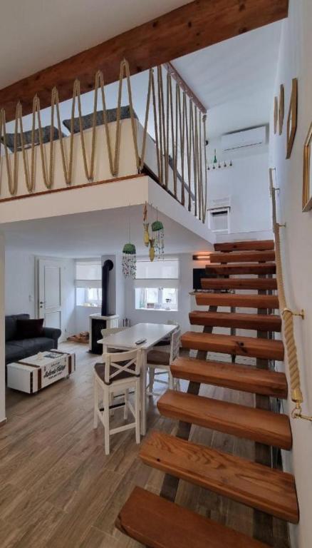 a room with a staircase and a living room with a table at Apartman Manuela in Pag