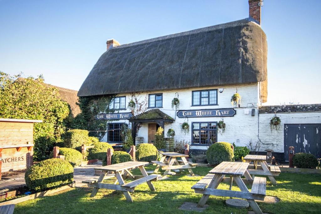 a building with picnic tables in front of it at The White Hart, Wroughton in Swindon