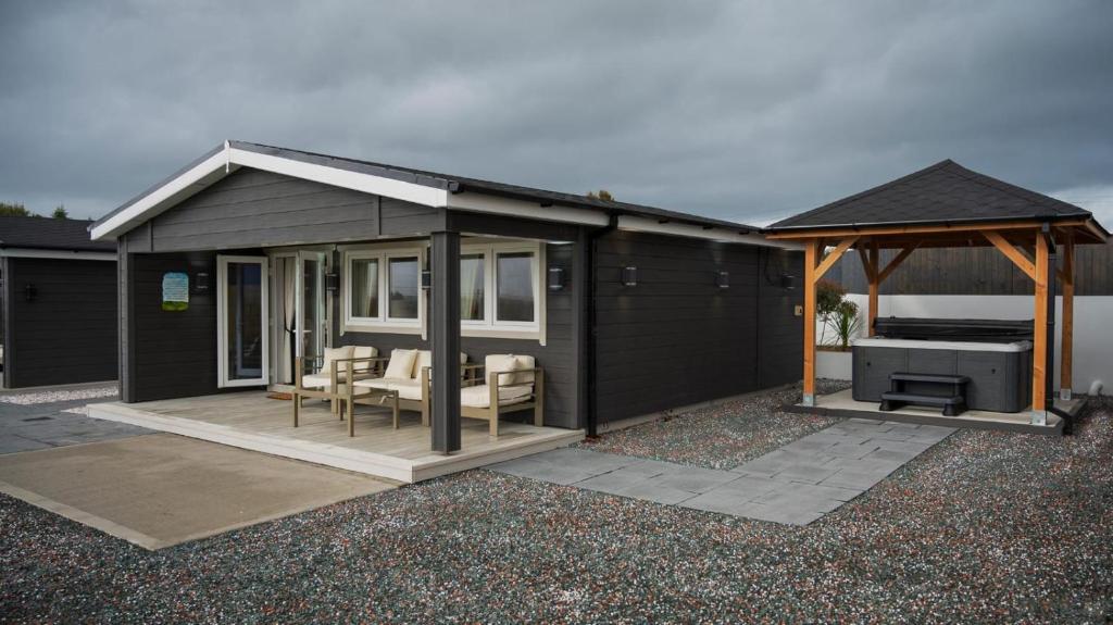 una casa nera con gazebo e grill di Danu Escape a Gneevgullia