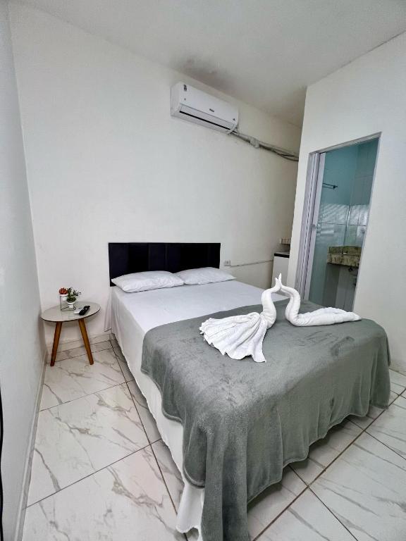 a bedroom with a bed with a swan statue on it at Pousada Velho Brito in Piranhas