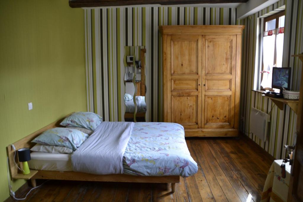 a bedroom with a bed and a wooden floor at Gîtes Du Stekala in Kaysersberg