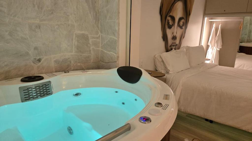 a bath tub in a room with a bed at Up Hotel Boutique in Bombinhas