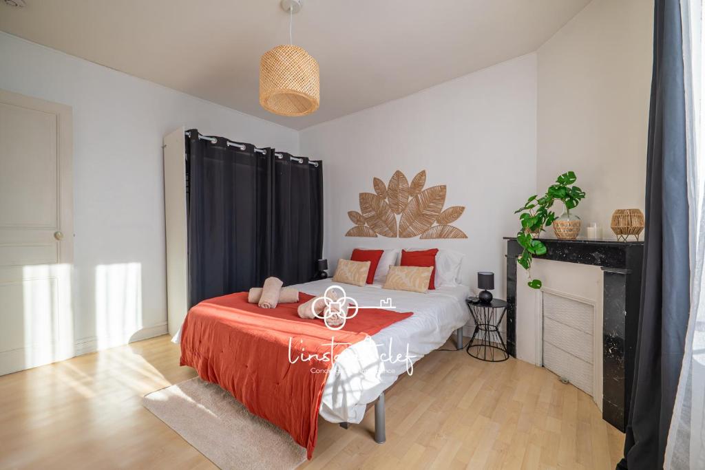 a bedroom with a bed with a red blanket at Fécomsi Escale - Un cocon au Mans - L'Instant Clef in Le Mans