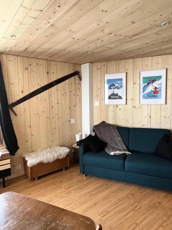 - un salon avec un canapé bleu et des murs en bois dans l'établissement Résidence Sefcotel - Studio pour 4 Personnes 574, à Tignes