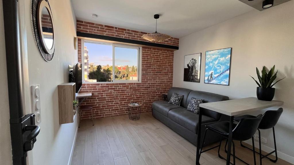 un salon avec un canapé et une table dans l'établissement Studio 3étoiles à 10 min du Centre - Calme, à Cannes