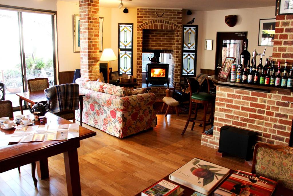 sala de estar con sofá y chimenea en Hotel Wellies en Karuizawa