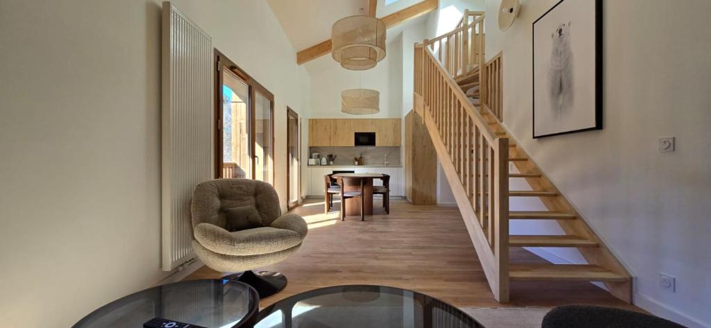 une chambre avec un escalier, une chaise et une table dans l'établissement Au Beau Séjour, à Samoëns