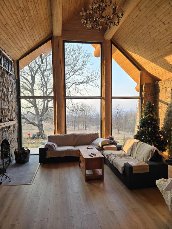 a living room with two couches and a fireplace at Cabana Ursului Tebea in Ţebea