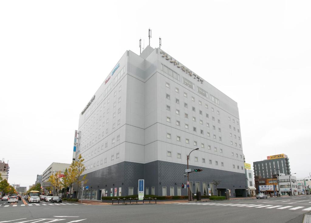 a large white building on the corner of a street at Yonago Washington Hotel Plaza in Yonago