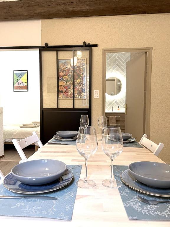 une table avec des assiettes et des verres à vin dessus dans l'établissement Le COSY NÎMOIS, charme et terrasse au cœur de Nîmes, à Nîmes