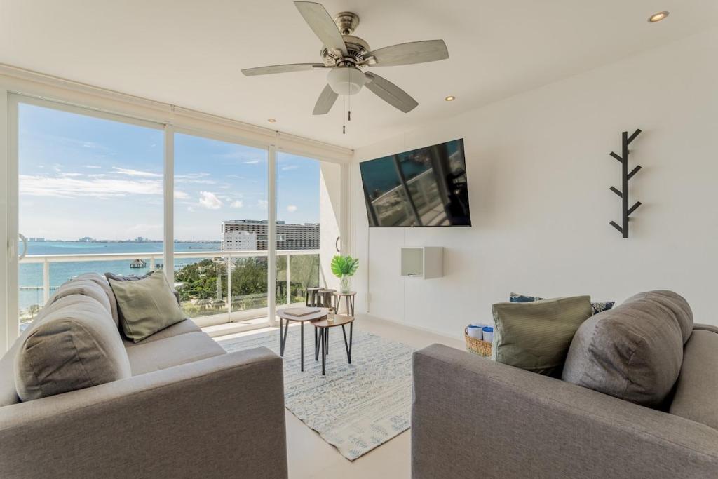 ein Wohnzimmer mit zwei Sofas und einem großen Fenster in der Unterkunft SEASlDE Beachfront 4 BDR by Casa Paraiso in Cancún