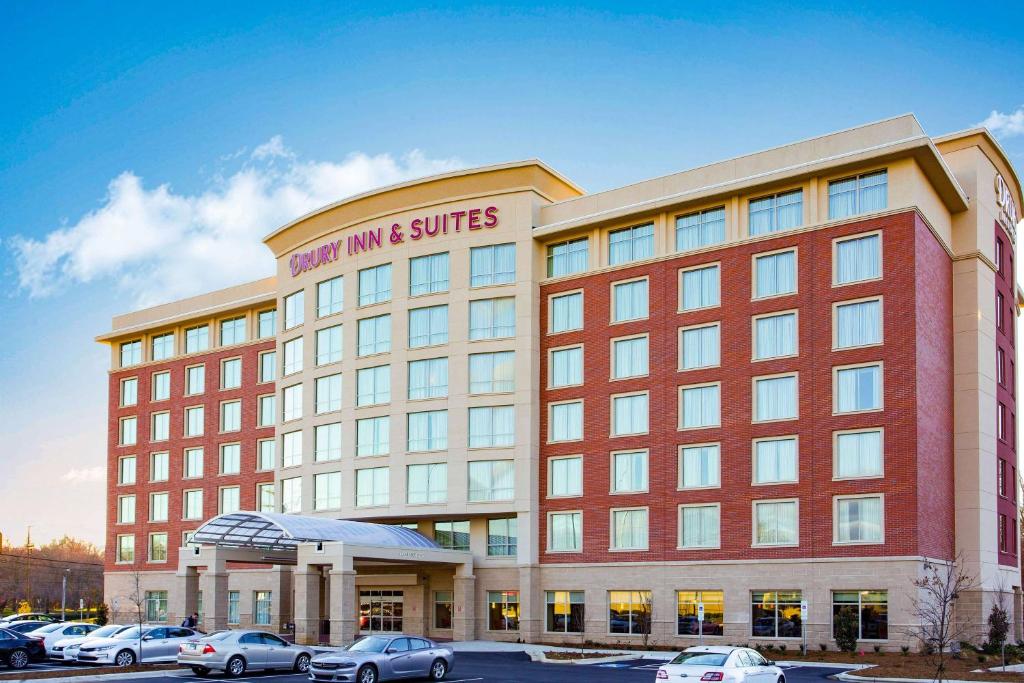 a large building with cars parked in a parking lot at Drury Inn & Suites Charlotte Arrowood in Charlotte