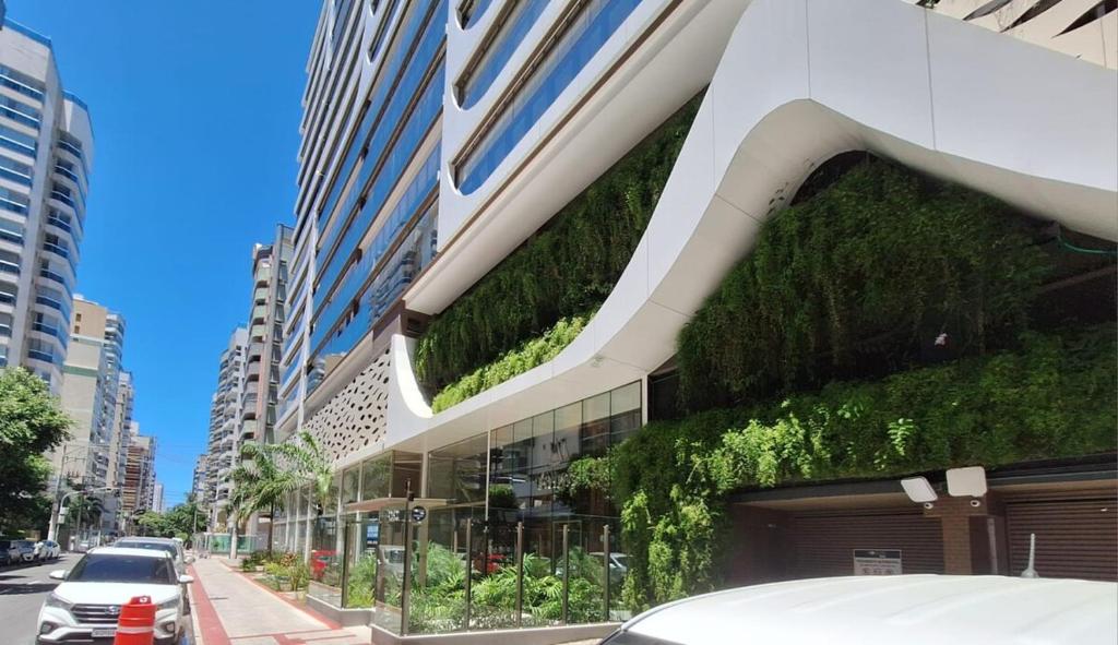 a building with a green wall on the side of it at Apartamento luxo, pertinho do Mar e lazer maravilhoso in Vila Velha