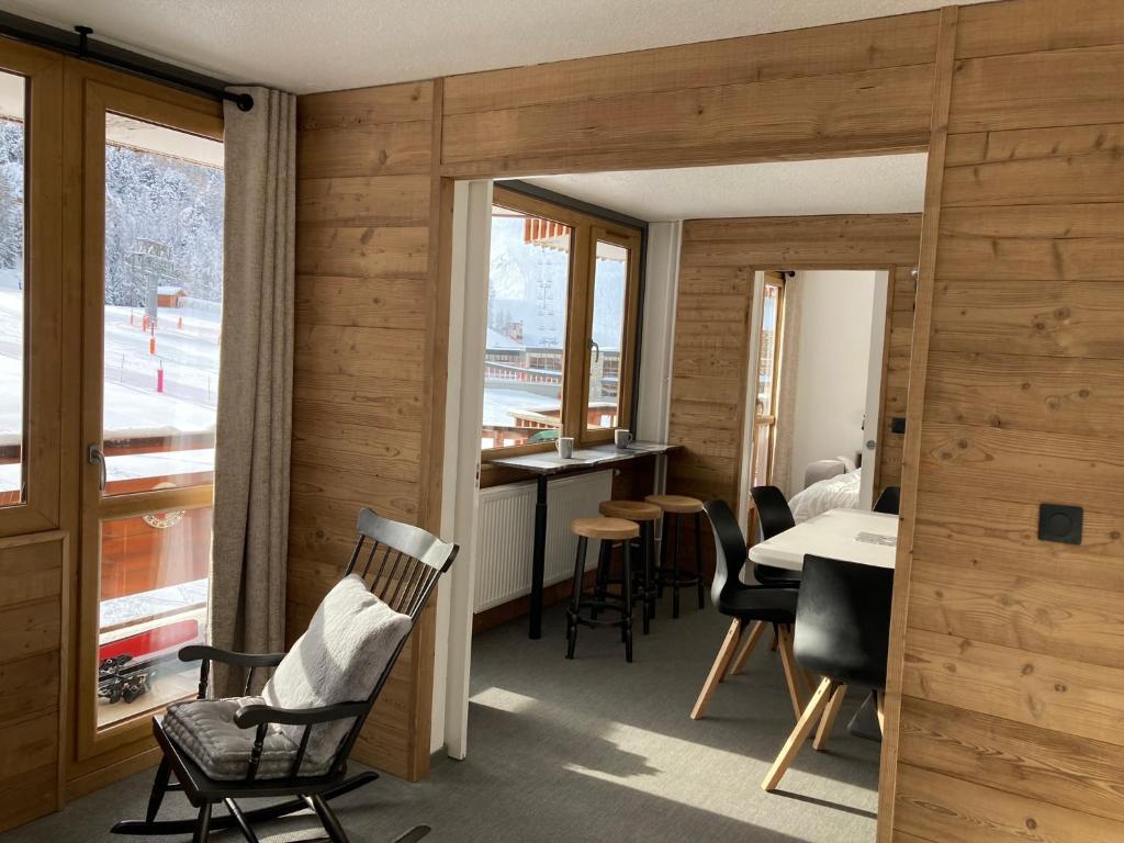 d'une salle à manger avec des chaises, une table et une fenêtre. dans l'établissement Appartement 4 pièces - 8 personnes - Résidence le France, à La Plagne Tarentaise