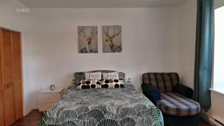 un dormitorio con una cama y una silla en Cozy Suite #3 in the Heart of DT Quebec with QB, en Quebec