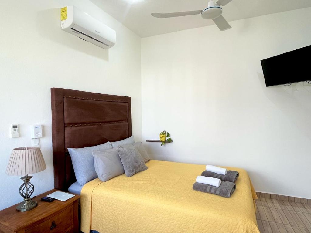 a bedroom with a bed with a yellow bedspread at Perfect Place Cozumel - DIANA in Cozumel