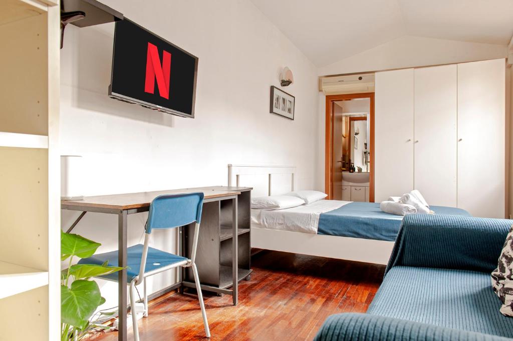a bedroom with a desk and a bed and a tv at Oasi urbana ( Due passi dal Centro / Stazione ) in Pontedera