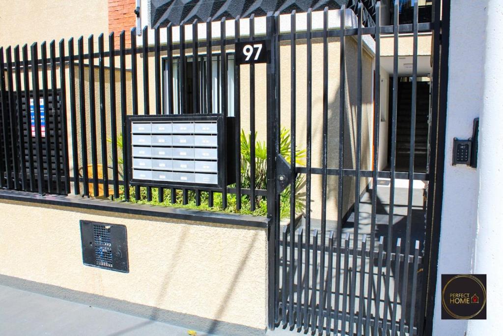 a black gate with a sign on the side of a building at Perfect Home in Guarulhos