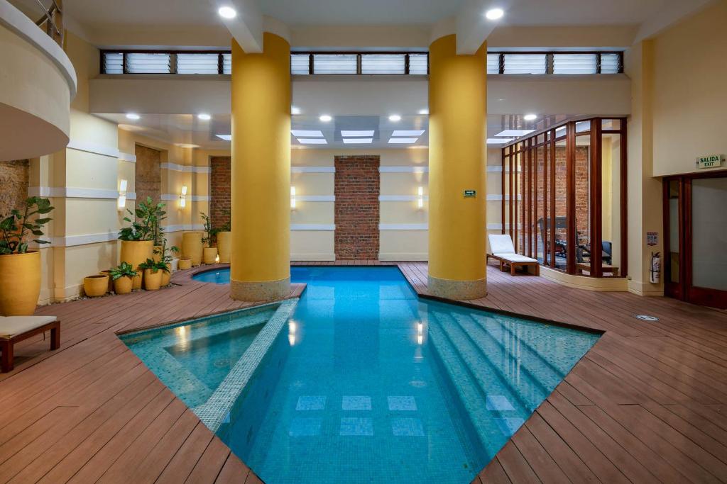 ボゴタにあるHotel De La Operaの柱のあるロビーのスイミングプール