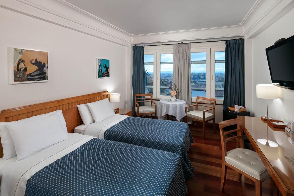 ボゴタにあるHotel De La Operaのベッド2台とテーブルがあるホテルの部屋