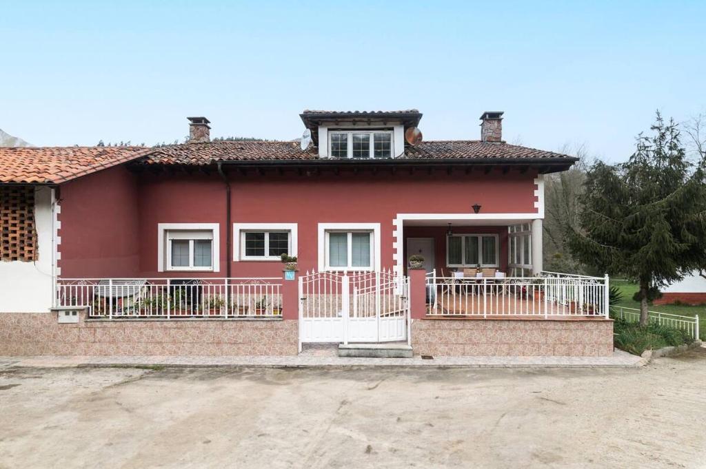 a red house with a porch and a balcony at La Teyera de Pili in Allende