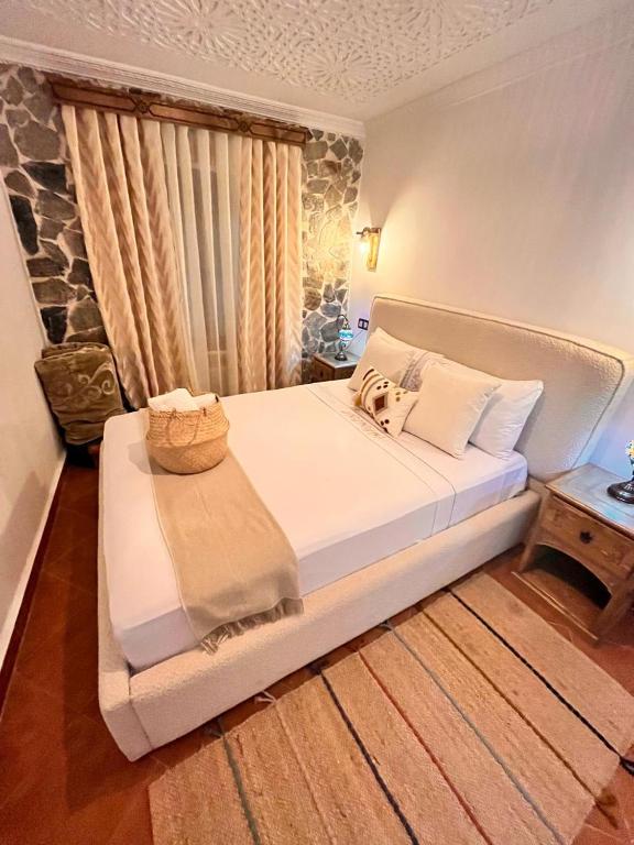 a bedroom with a white bed with a basket on it at Riad abi khancha in Chefchaouen
