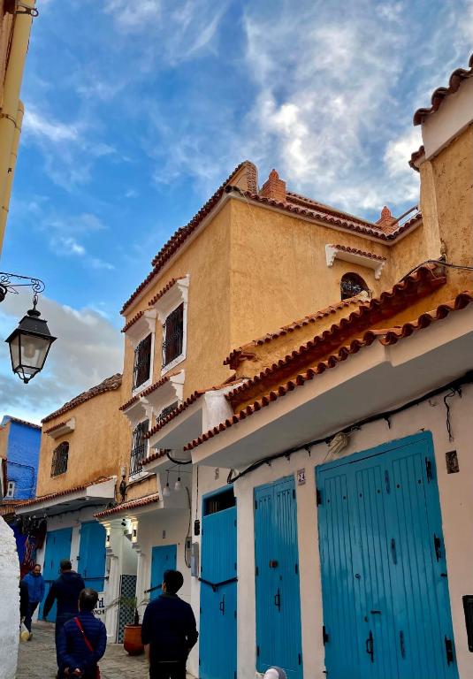 a building with blue doors on a street at Riad abi khancha in Chefchaouen