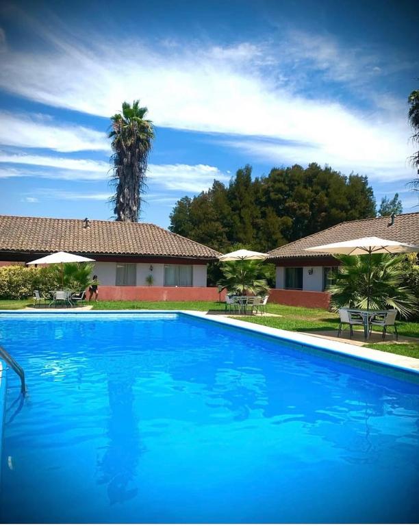 a large blue swimming pool in front of a house at Apart hotel Entre Ríos ruta 5 Talca in Talca