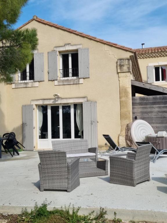 un patio avec des chaises et une table devant une maison dans l'établissement Gîte l'olivier, à Mézoargues