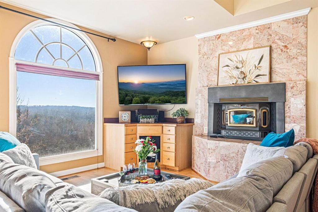 a living room with a fireplace and a tv at Majestic River Castle, A Fairytale Escape on the Coosawatee River in Ellijay