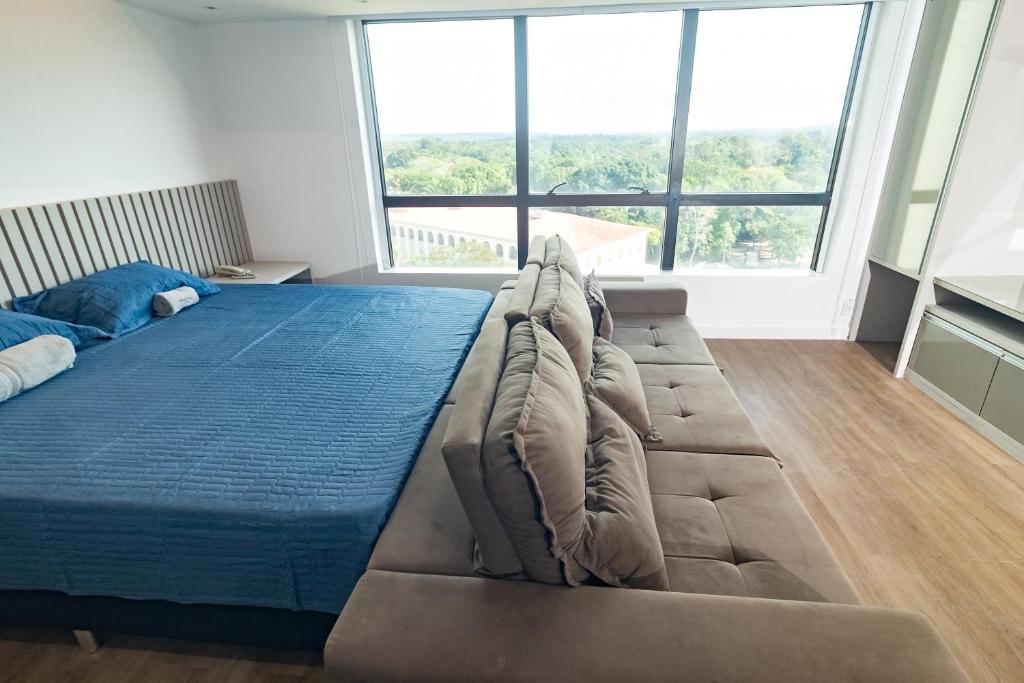 1 cama grande en una habitación con ventanas grandes en Tropical Executive Suite Flat 1001 Veiw, en Manaus