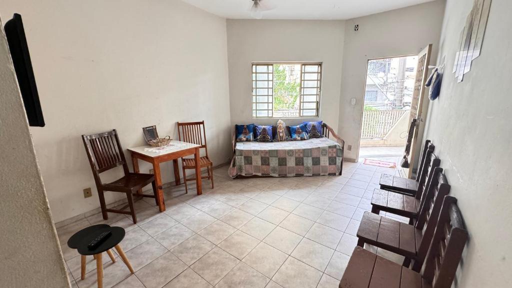 a room with a bed and a table and chairs at APARTAMENTO PRIMEIRO ANDAR COM GARAGEM E RECEPÇÃO 24 horas in Aparecida