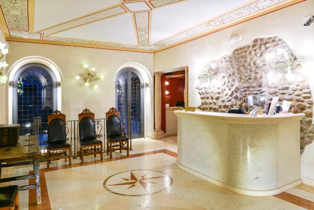 eine Lobby mit Stühlen und einer Theke in einem Gebäude in der Unterkunft Residence ANTICO SAN ZENO centro storico in Verona