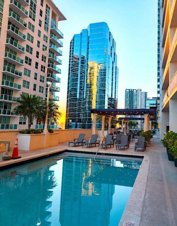a swimming pool with chairs and buildings in the background at Two Bedroom Oceanview Apartment in Brickell in Miami