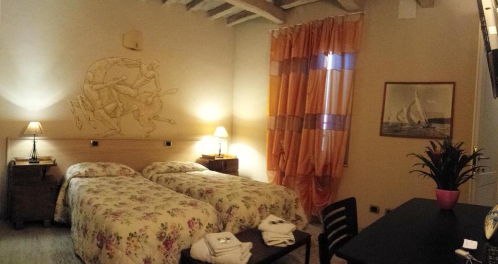 a hotel room with two beds and a table at La Casa del Viandante in Modena