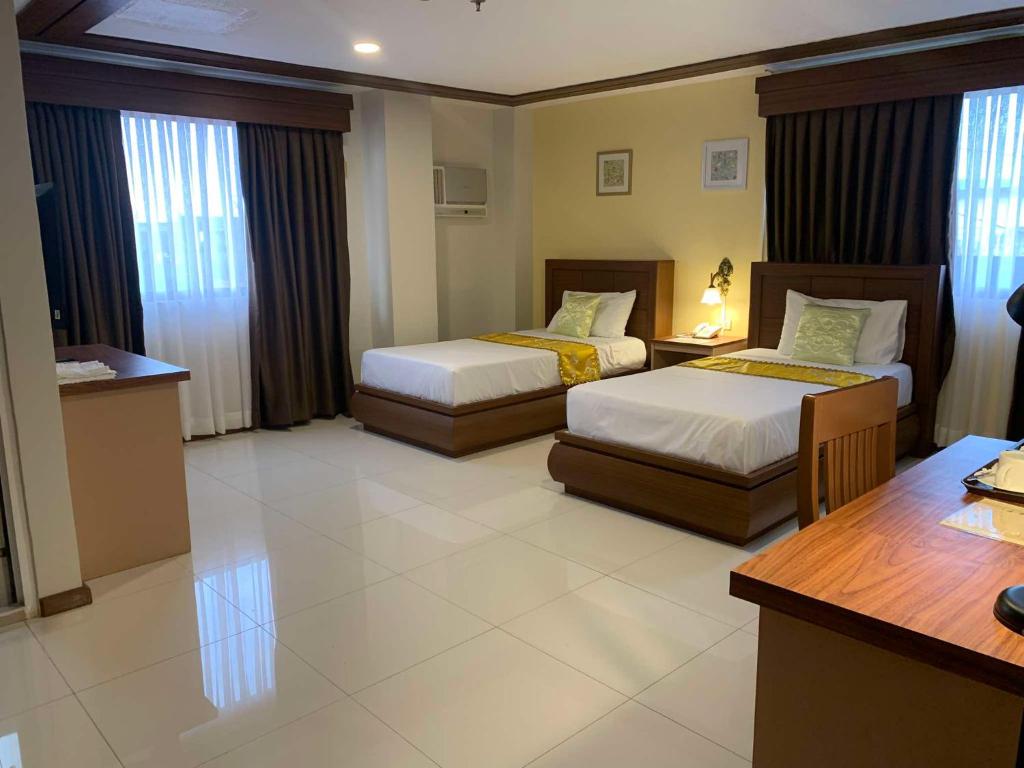 Postel nebo postele na pokoji v ubytování Surigao Royal Regency Suites