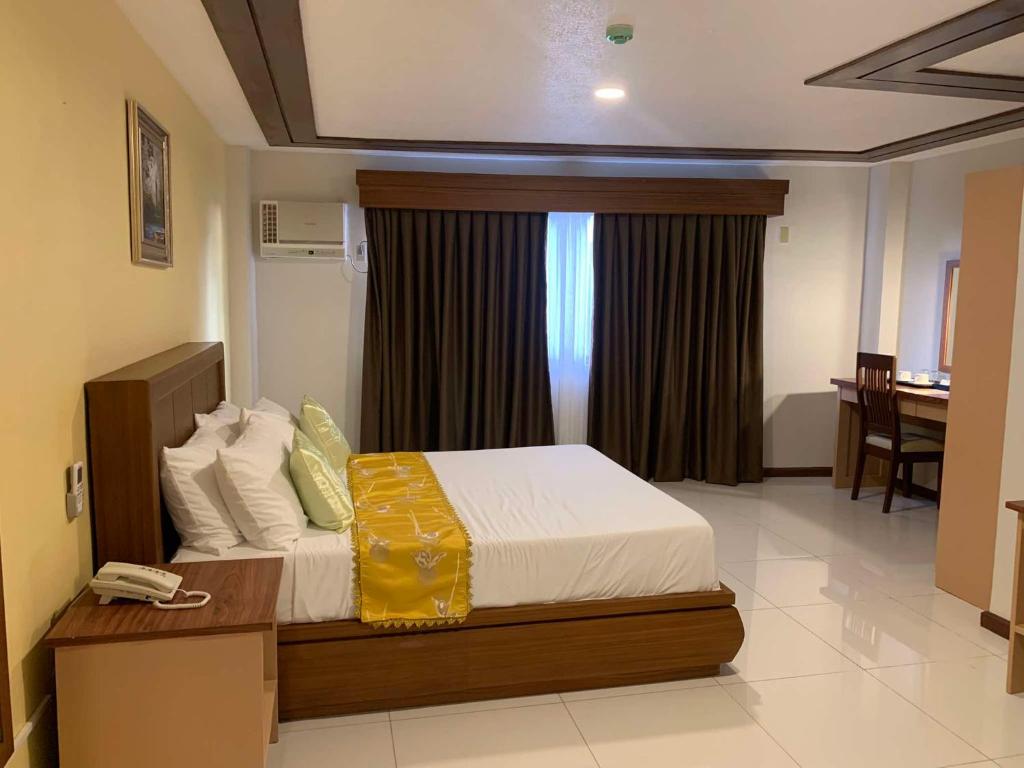 Postel nebo postele na pokoji v ubytování Surigao Royal Regency Suites