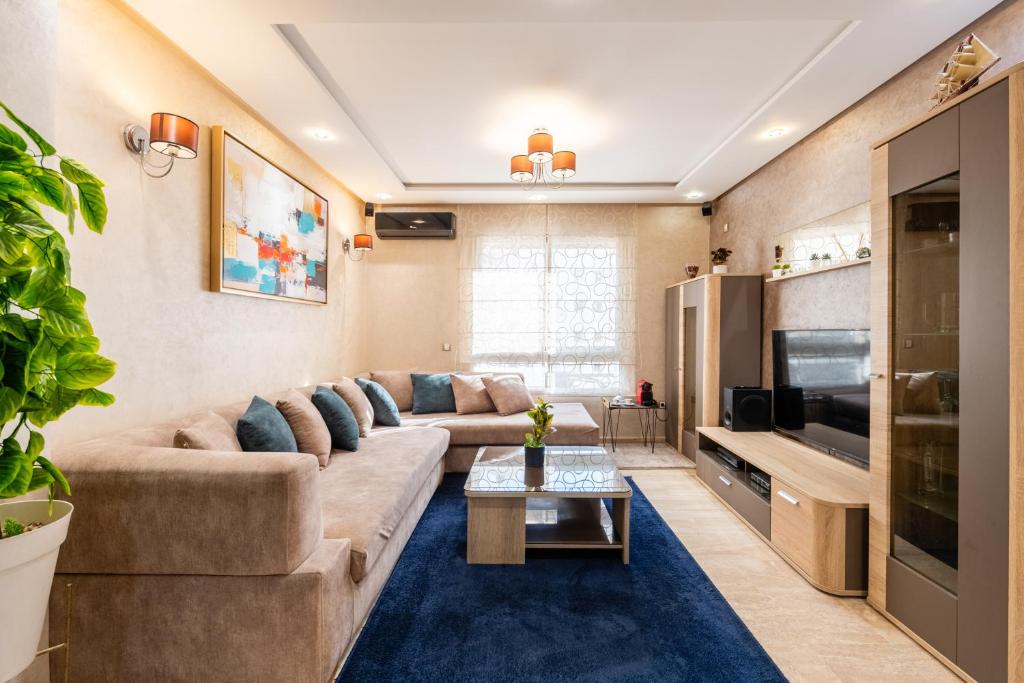 a living room with a couch and a tv at Casa Lucia Family Flat Optical Fiber in Rabat